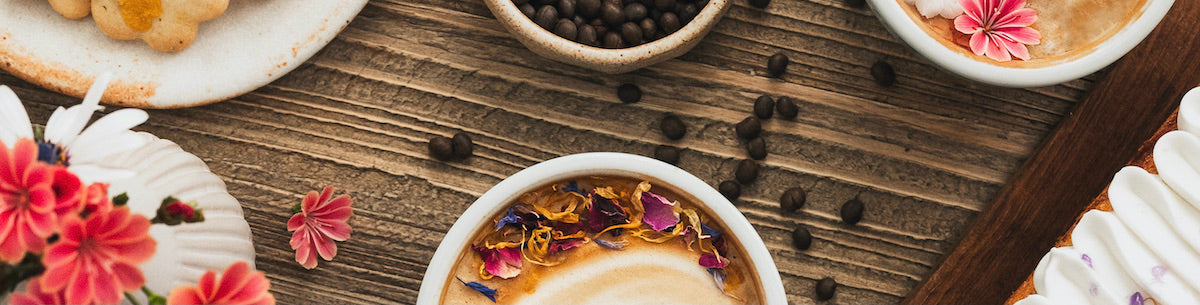 Café de lupin avec mousse de lait entouré de diverses pâtisseries et des graines de café de lupin